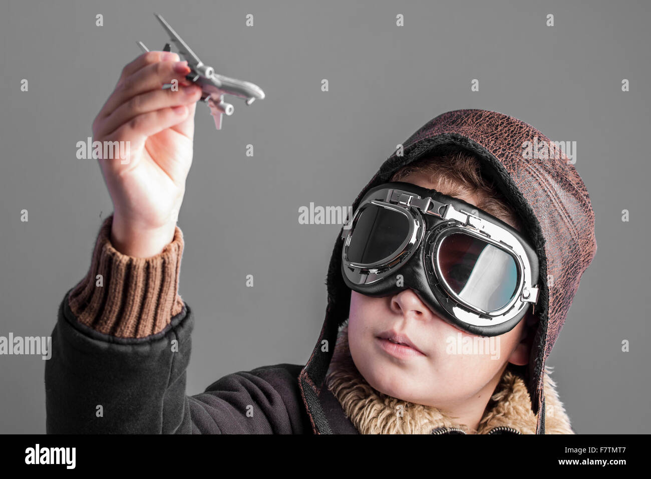 fun, child playing the aircraft pilot with hat and retro bomber jacket ...