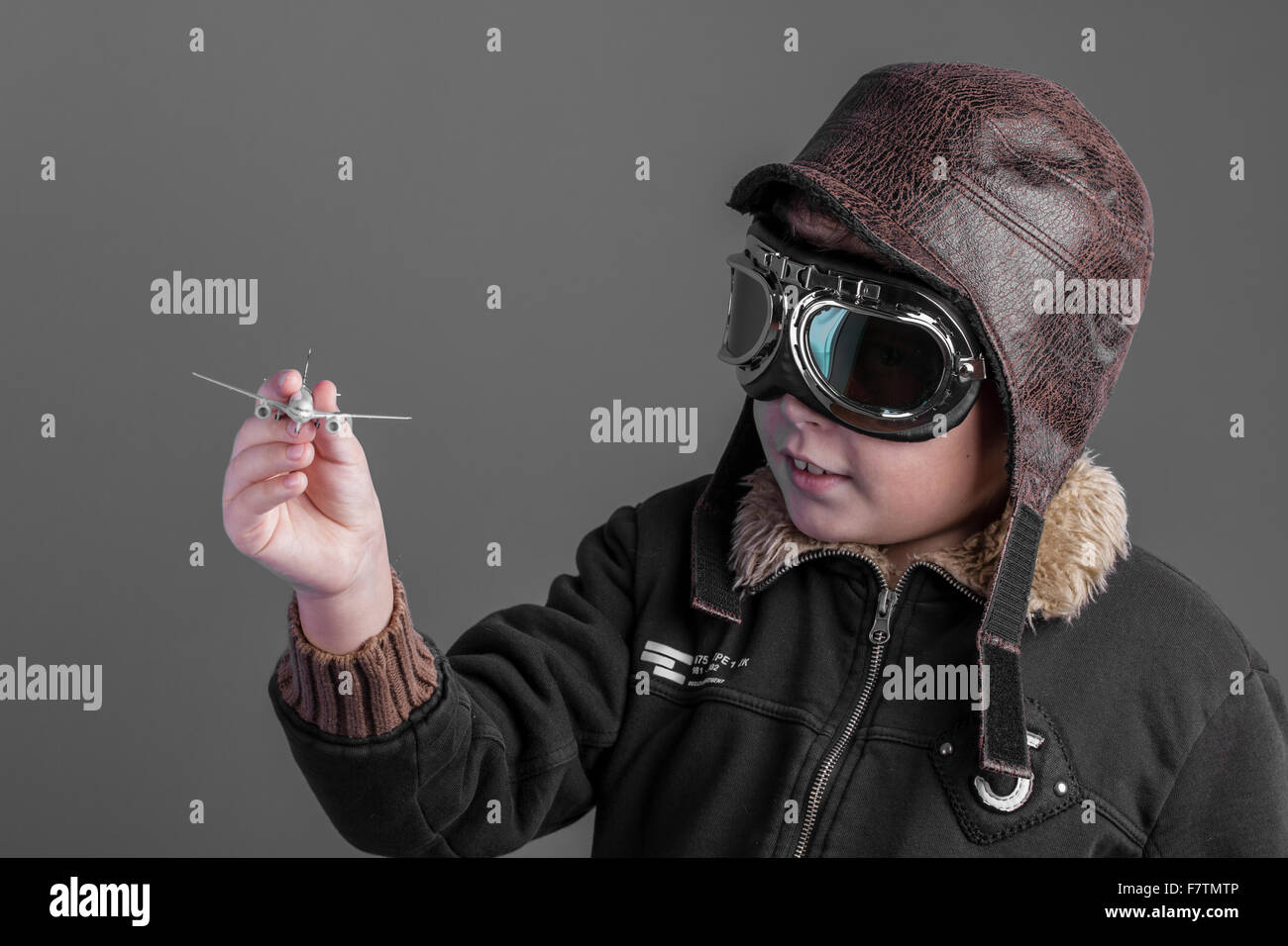toy, child playing the aircraft pilot with hat and retro bomber jacket ...