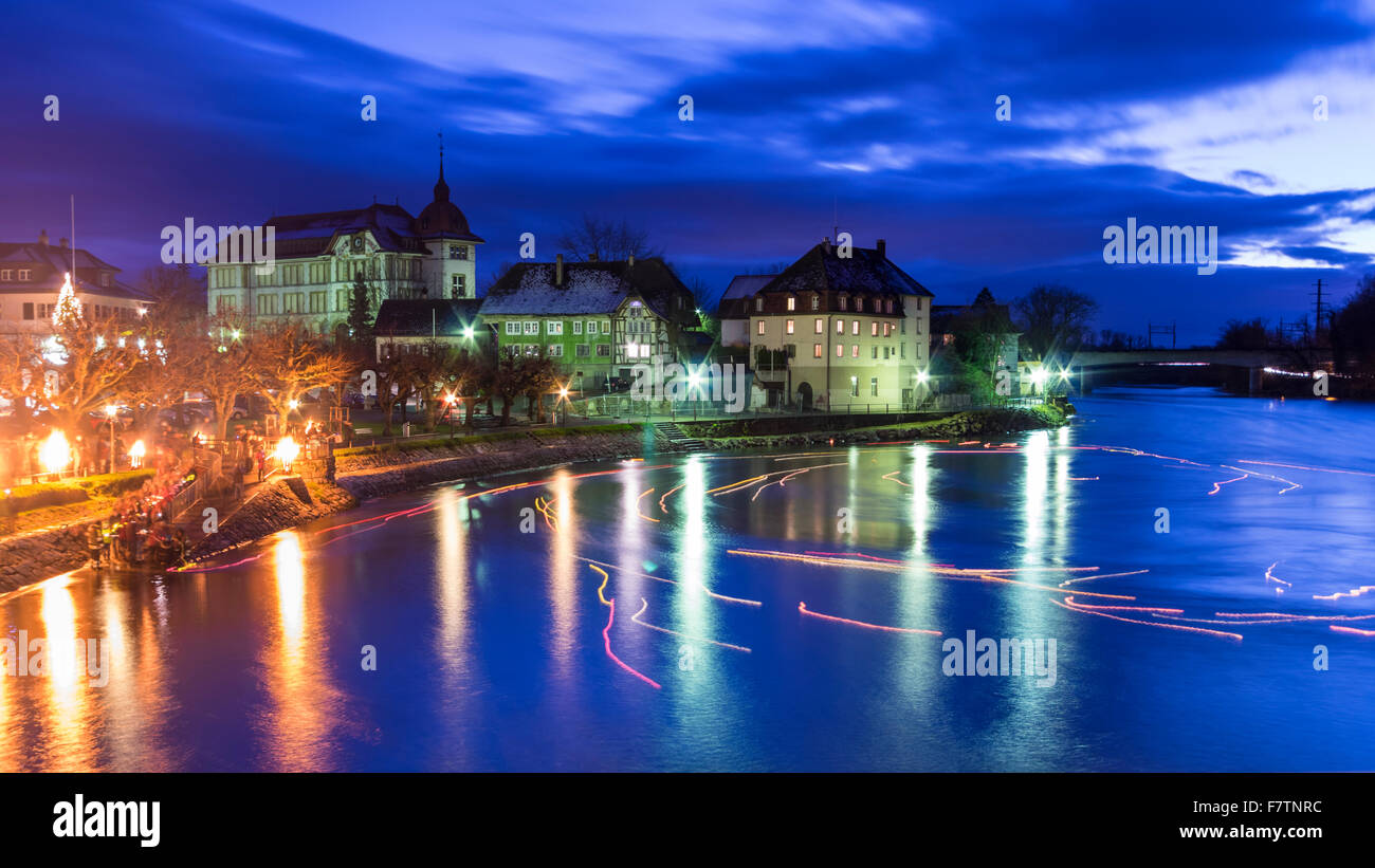 Waterfront of the town of Aarburg, Switzerland, at night, during the 'Aarburg leuchtet' Christmas event. Floating candles on Aare river. Stock Photo