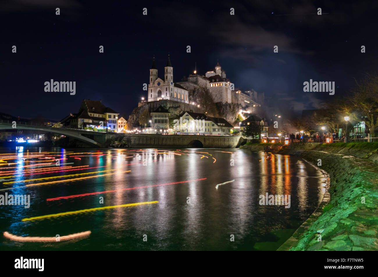 Church and fortress of the town of Aarburg, Switzerland, at night, during the 'Aarburg leuchtet' Christmas event. Floating candles on Aare river. Stock Photo