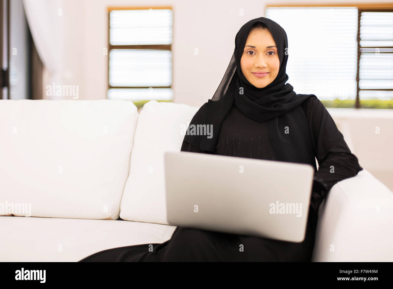 beautiful Muslim woman with laptop at home Stock Photo