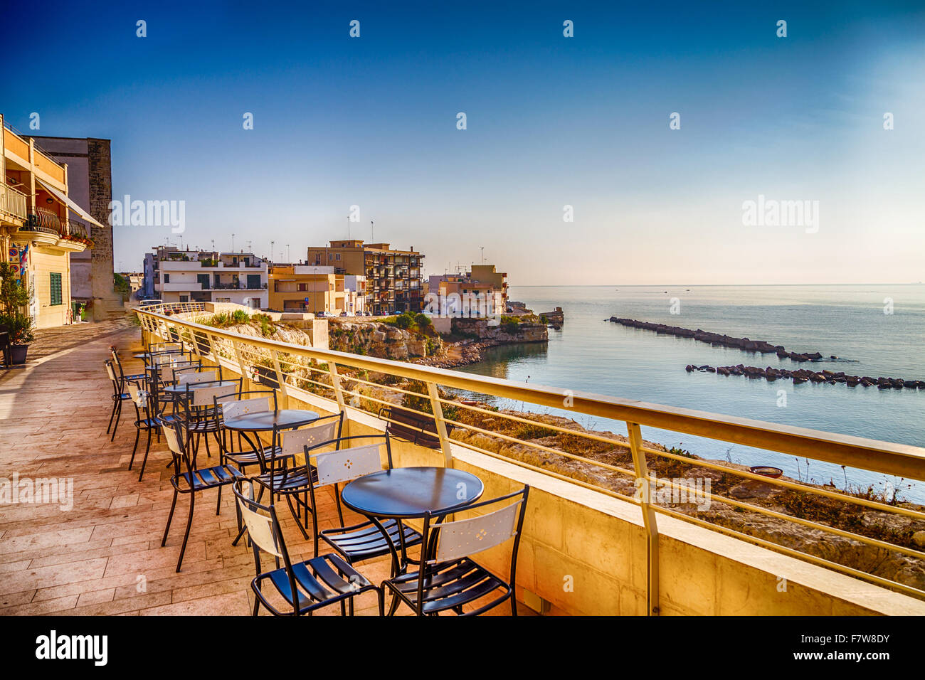 Coffee tables on Bay of Otranto, Greek-Messapian city on the Adriatic Sea in Italy Stock Photo