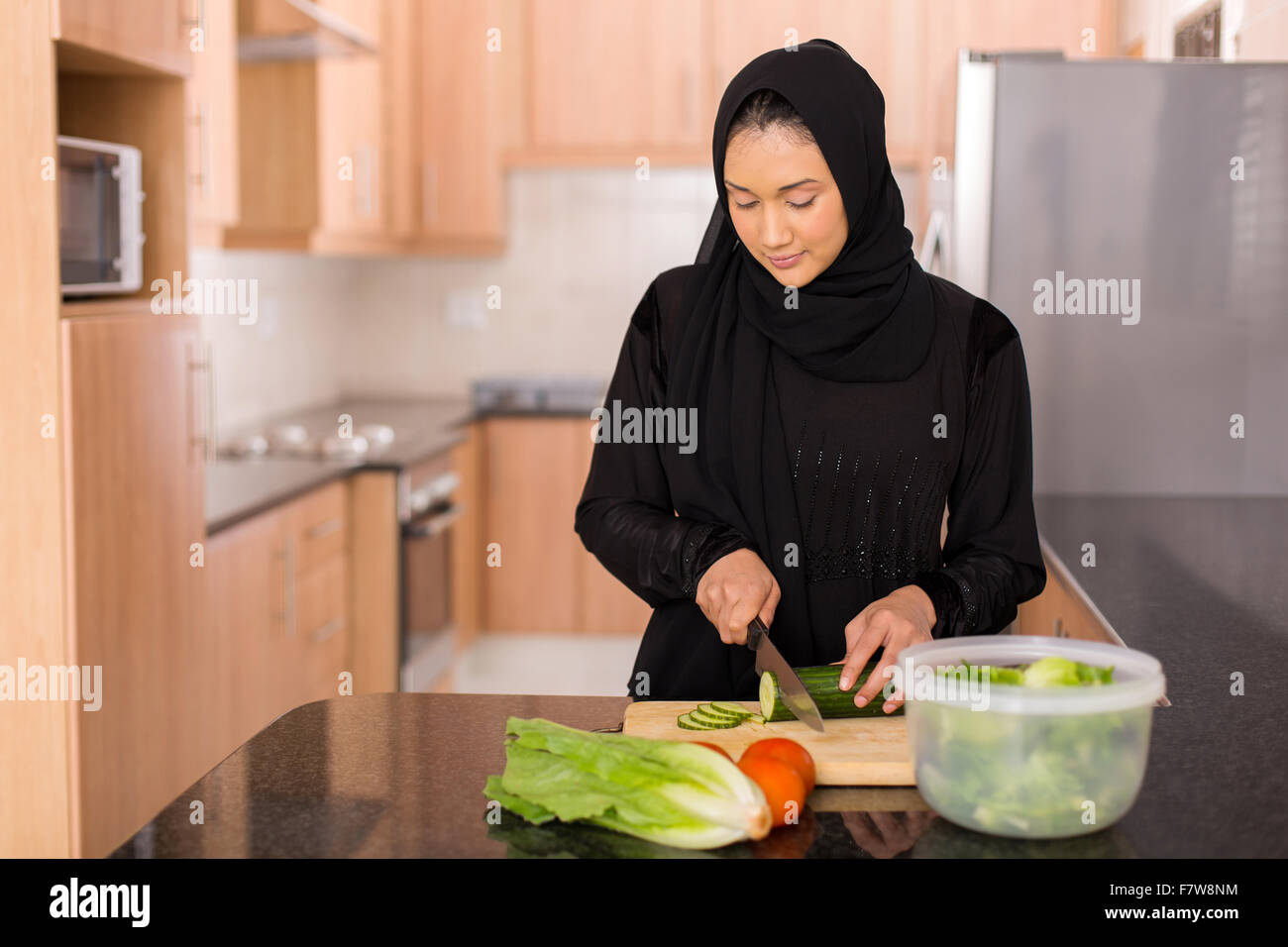 https://c8.alamy.com/comp/F7W8NM/pretty-muslim-woman-chopping-vegetables-in-kitchen-F7W8NM.jpg