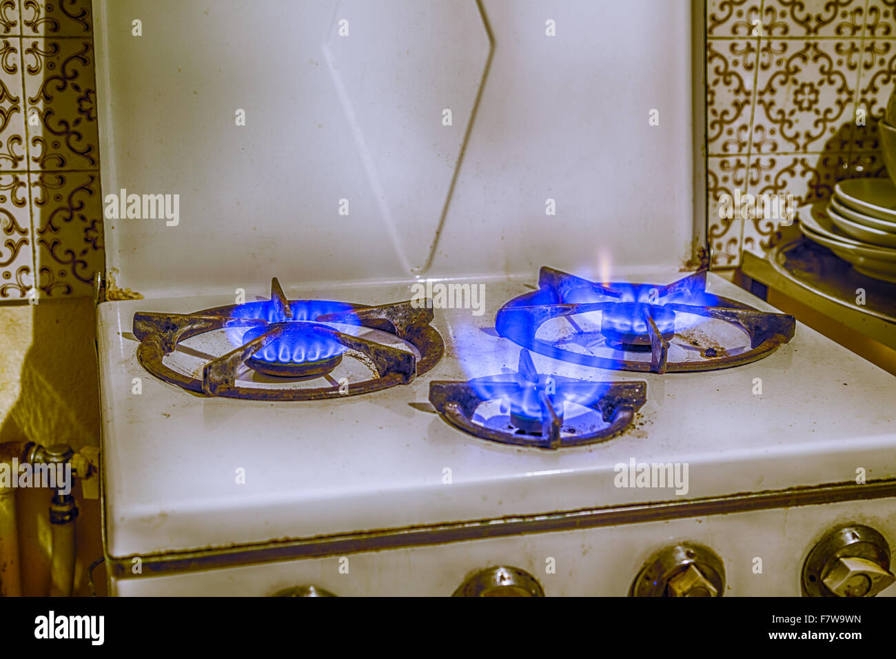 old encrusted gas stove with three fires Stock Photo