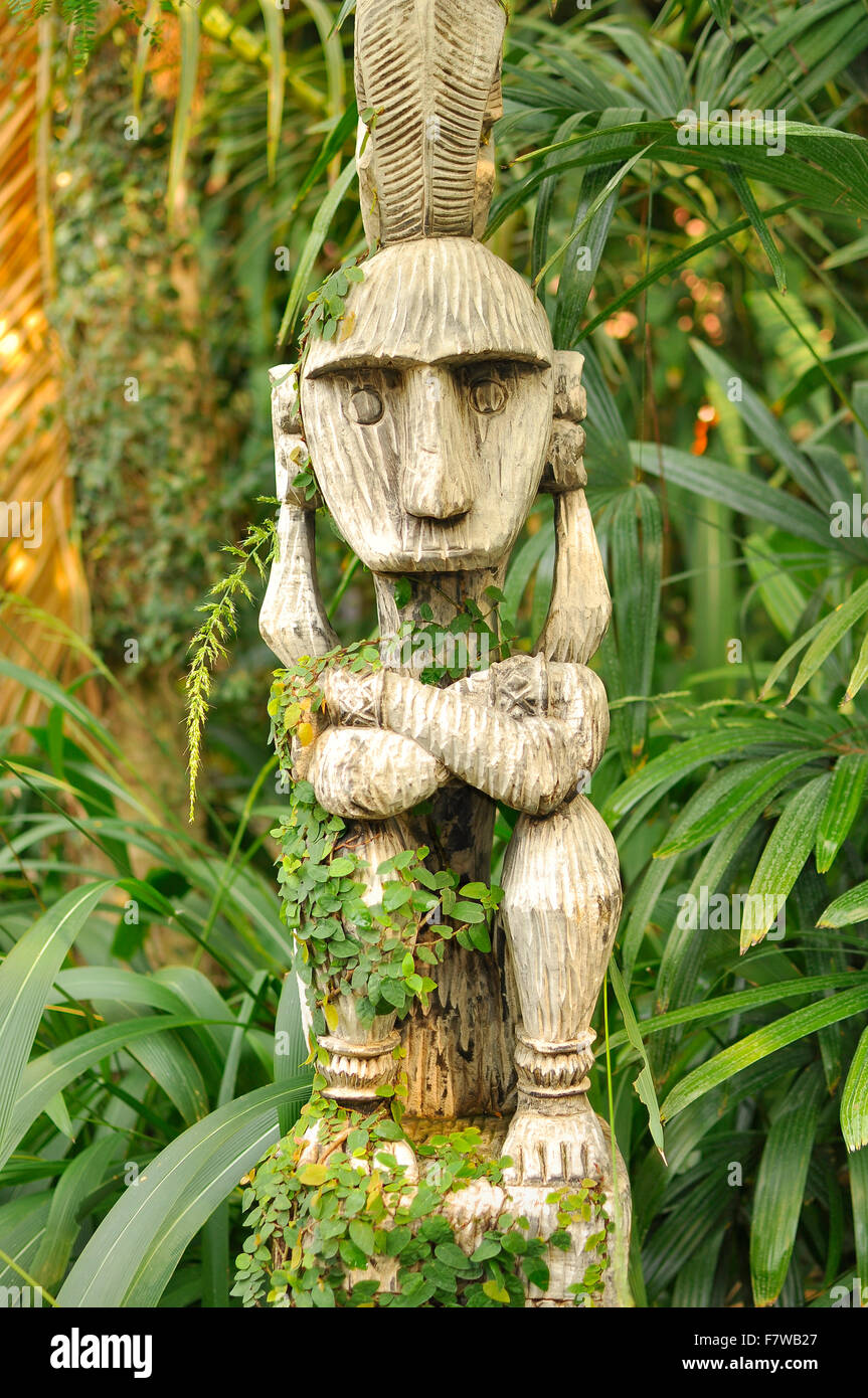 Dayak Totem - Southeast Asian overgrown tribal woodcarving in the jungle Stock Photo