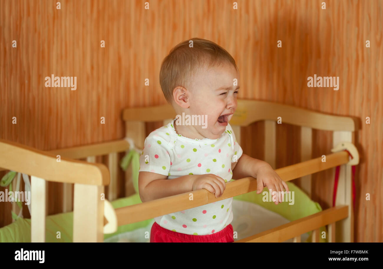 Crying baby of one year old in crib Stock Photo Alamy