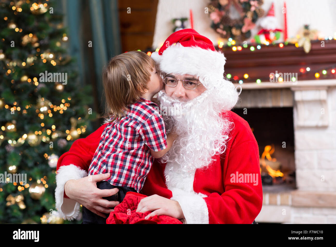 Santa Claus And Child Boy Kid Telling His Christmas Wish In Santa Claus Near The Christmas Tree Opposite Fireplace Stock Photo Alamy