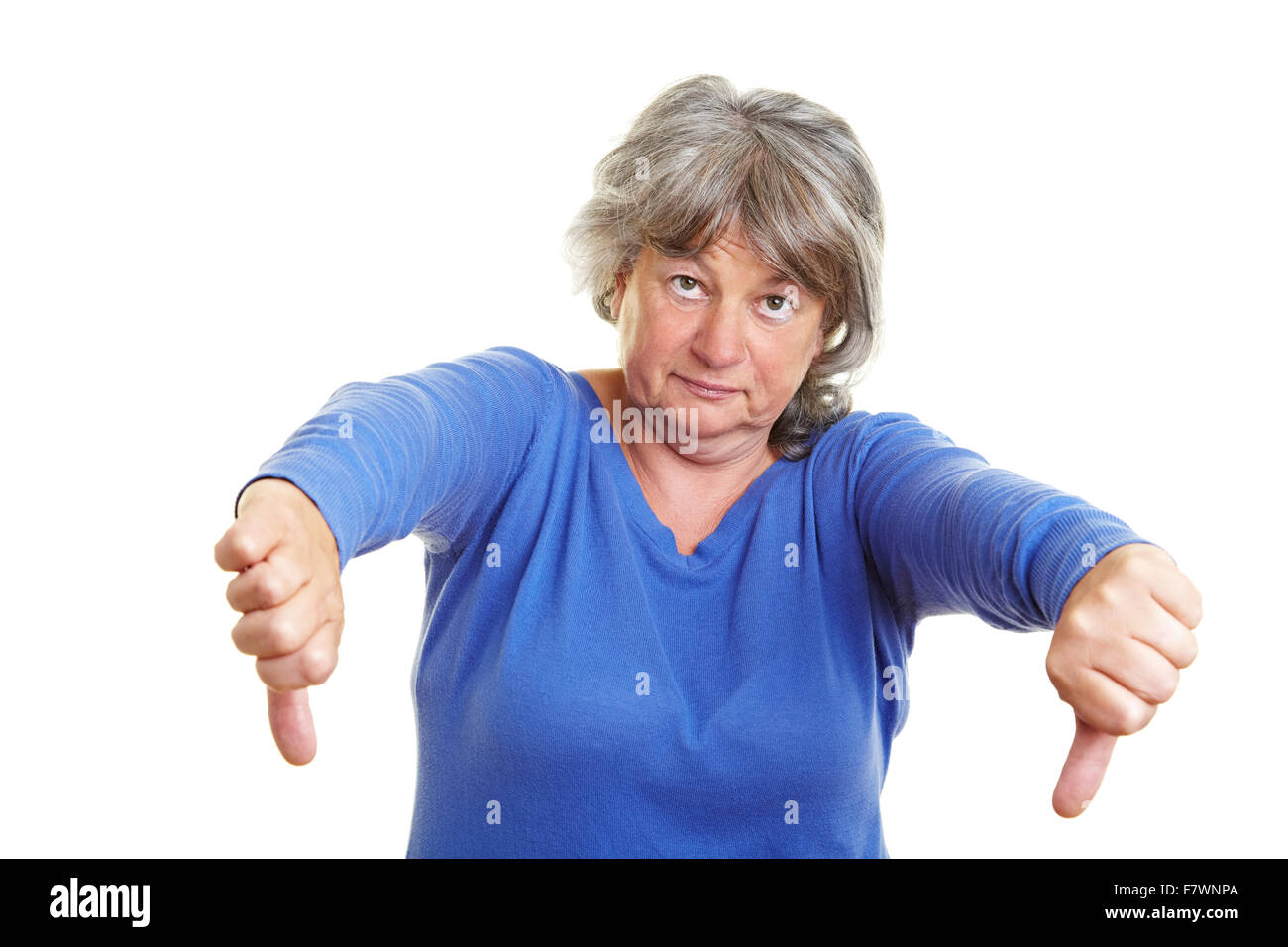 Senior woman pointing with her thumb down Stock Photo