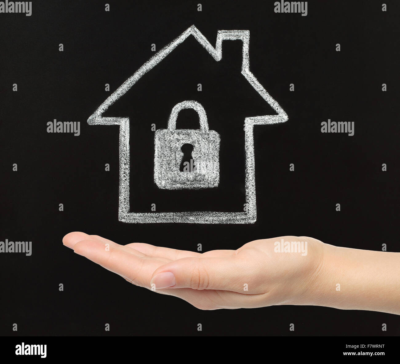 Home security concept. Chalk house with woman hand on blackboard background Stock Photo