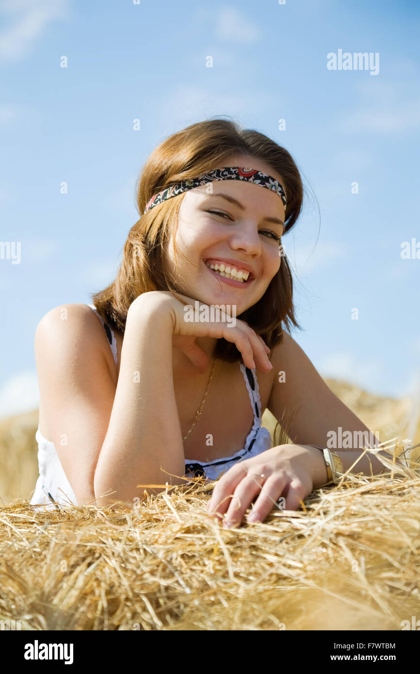 Country girl on fresh hay in summer Stock Photo