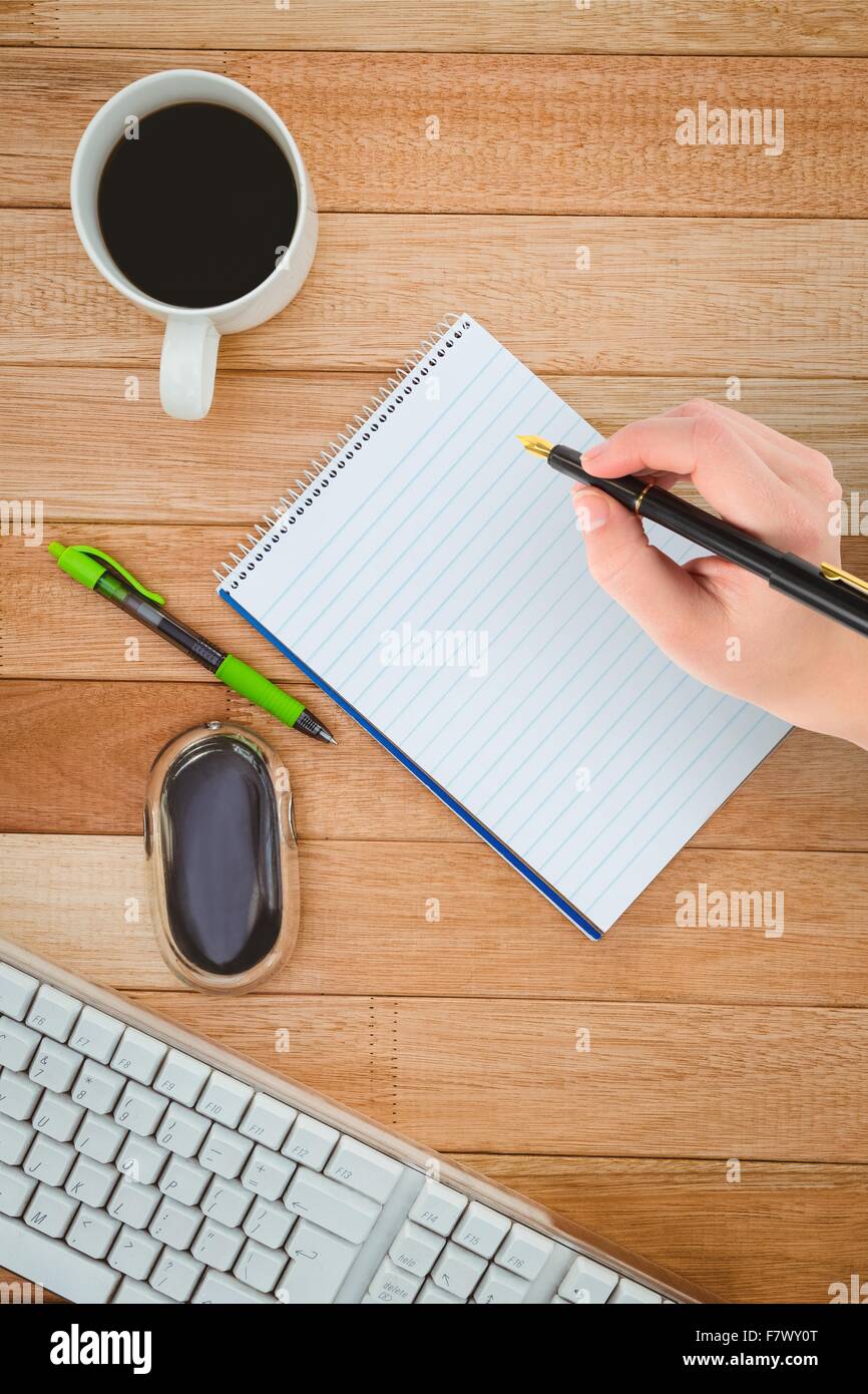 Composite image of businesswomans hand writing with fountain pen Stock Photo