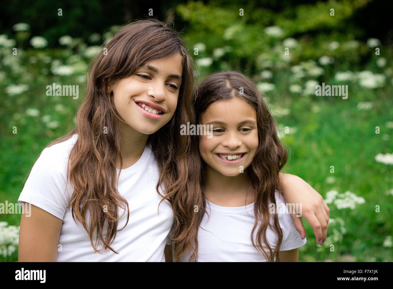 Two smiling girls hugging each other Stock Photo - Alamy