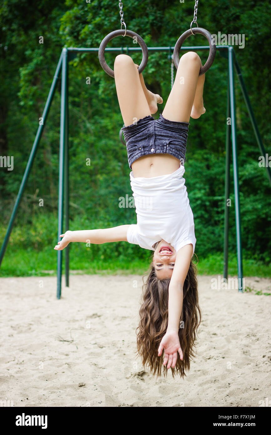 Young girl child playing in garden hanging upside down, MR#543