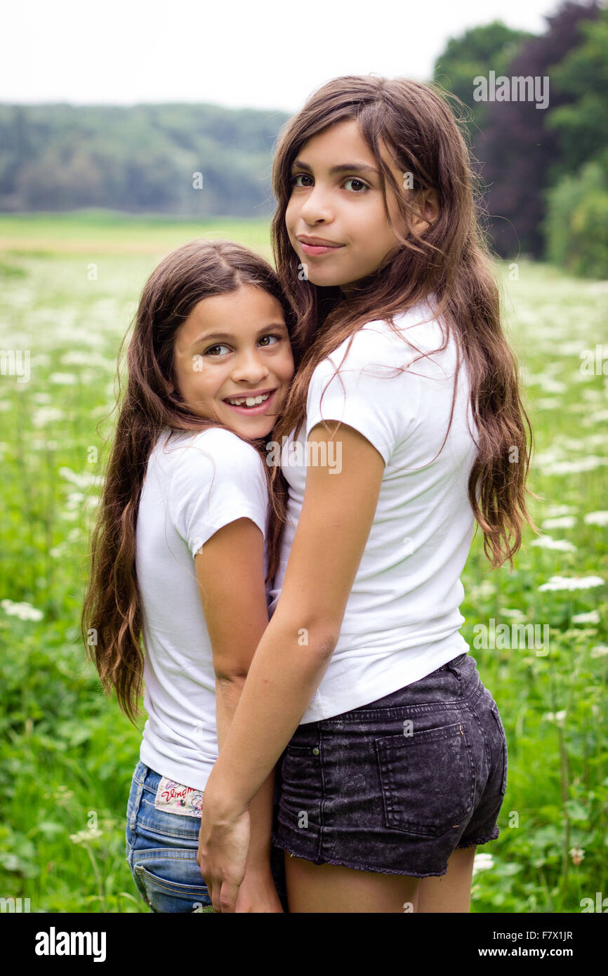 Portrait of two girls holding hands in the countryside Stock Photo