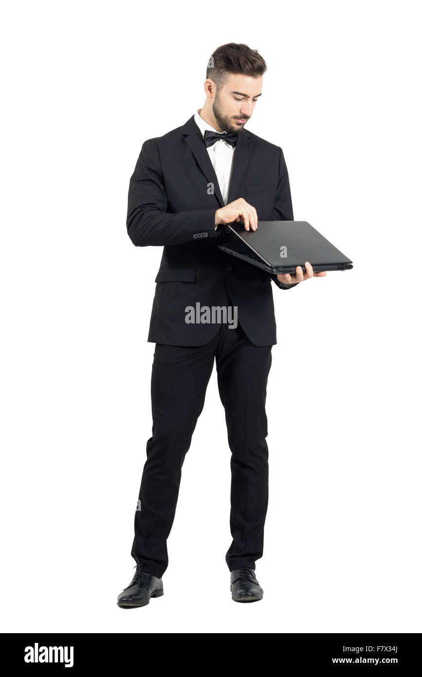 Young businessman opening laptop. Full body length portrait isolated ...