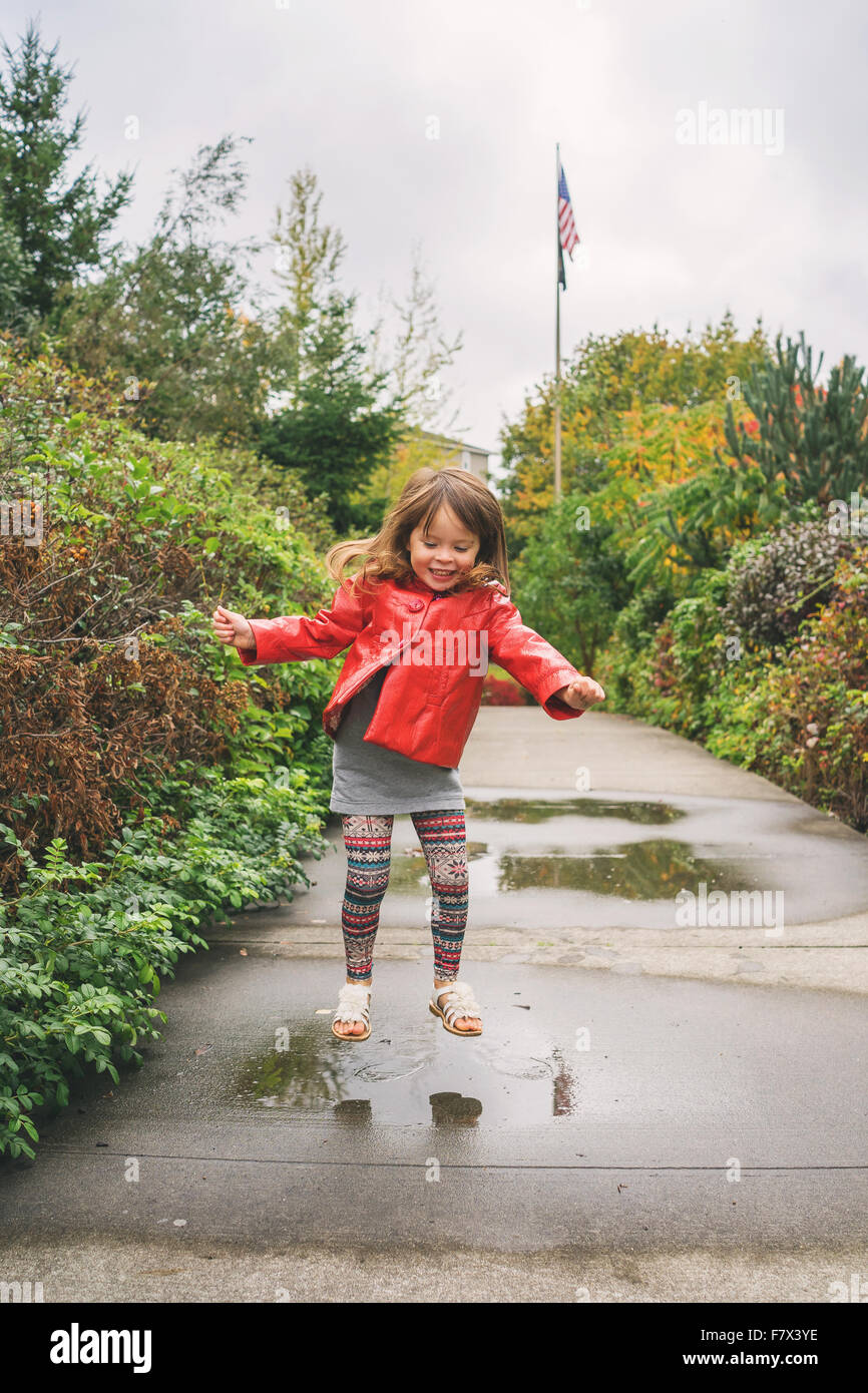 Girl jumping in a puddle Stock Photo