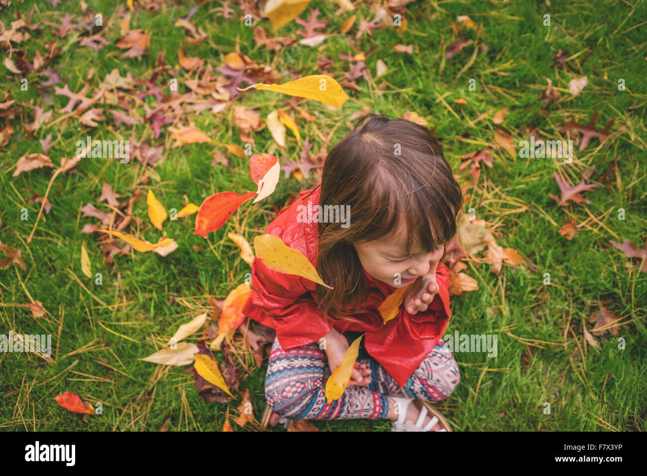 Smiling Girl sitting on grass Stock Photo
