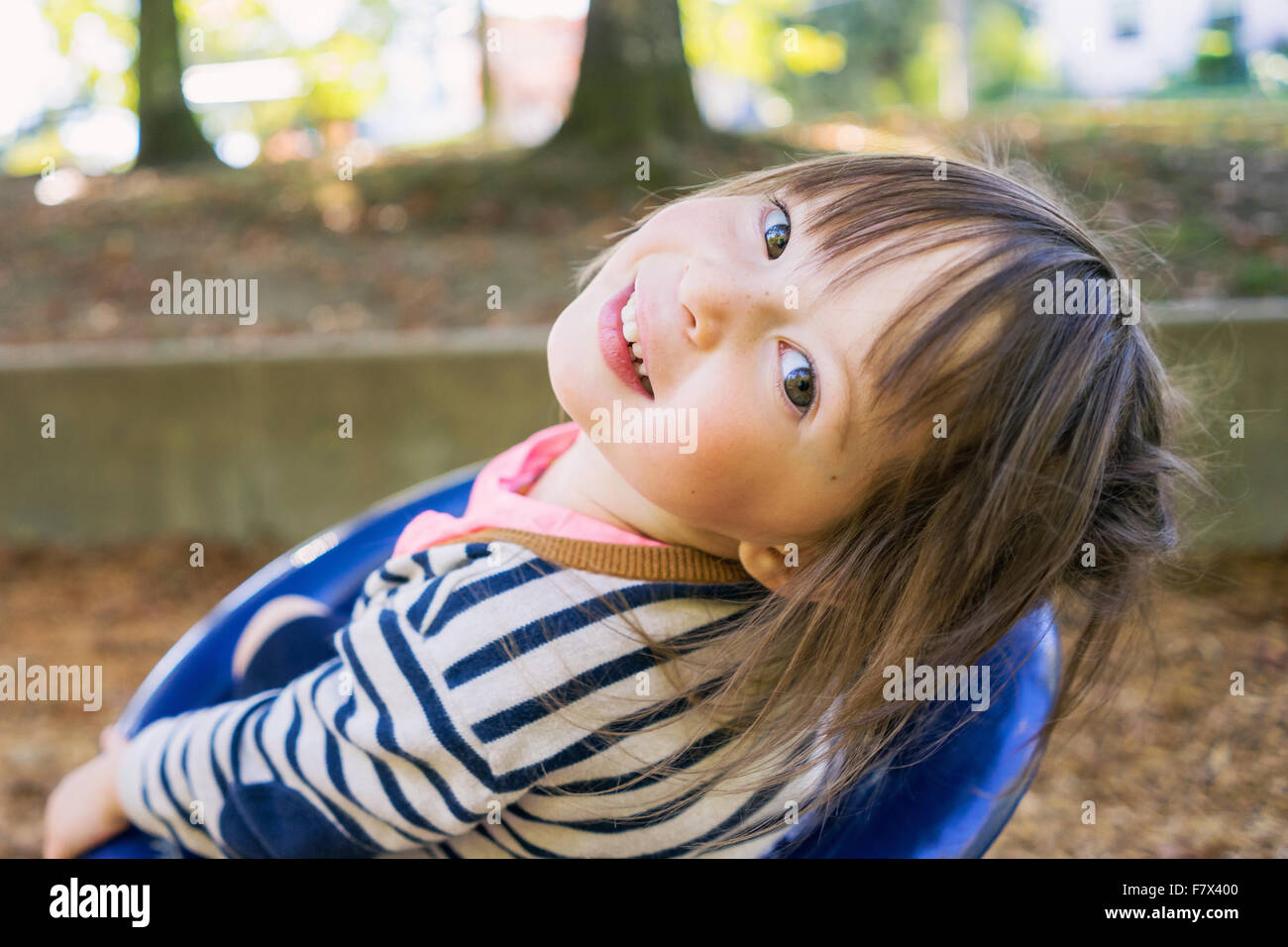 Smiling girl in playground looking over her shoulder Stock Photo