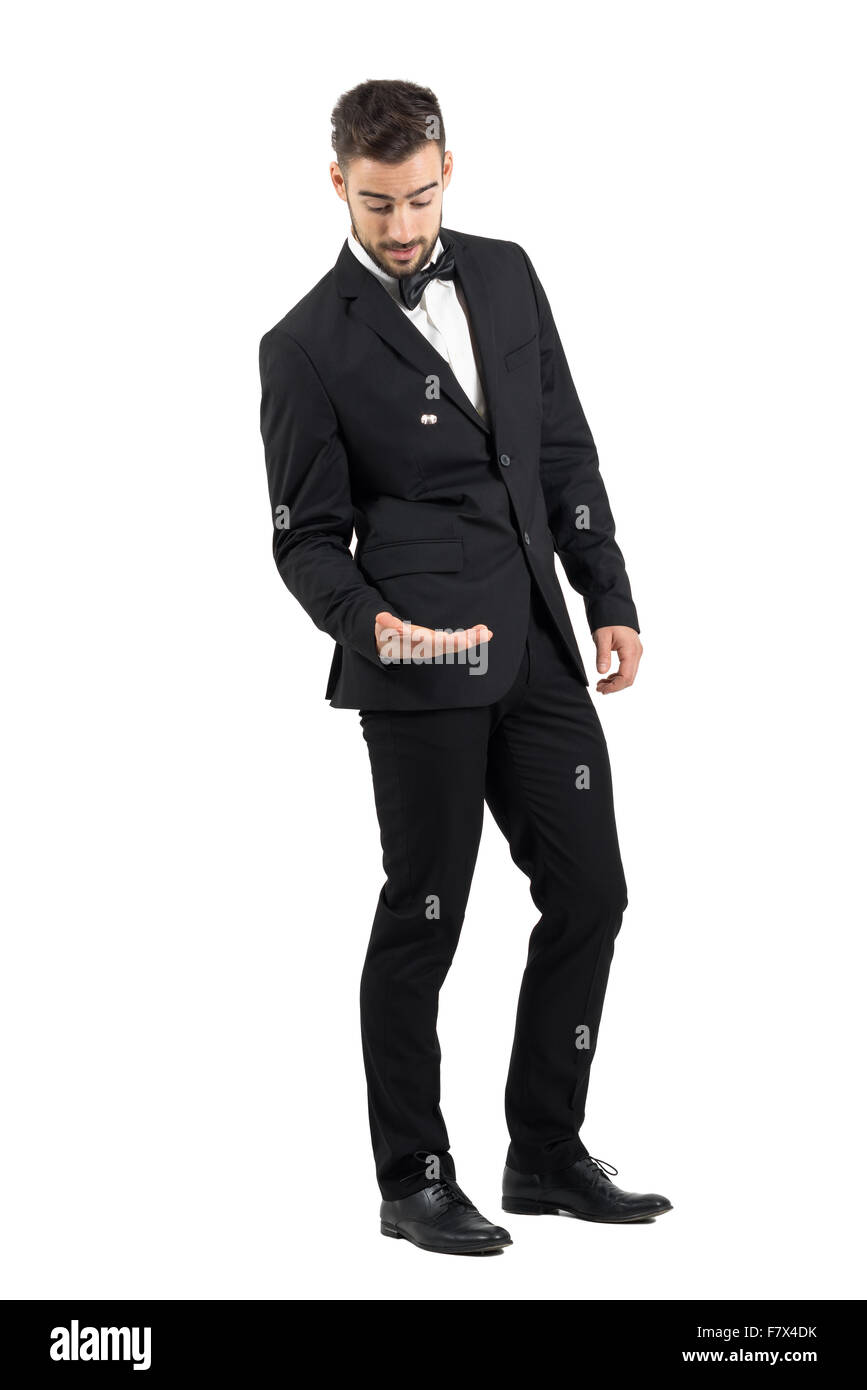 Young groom throwing and playing with wedding ring. Full body length portrait isolated over