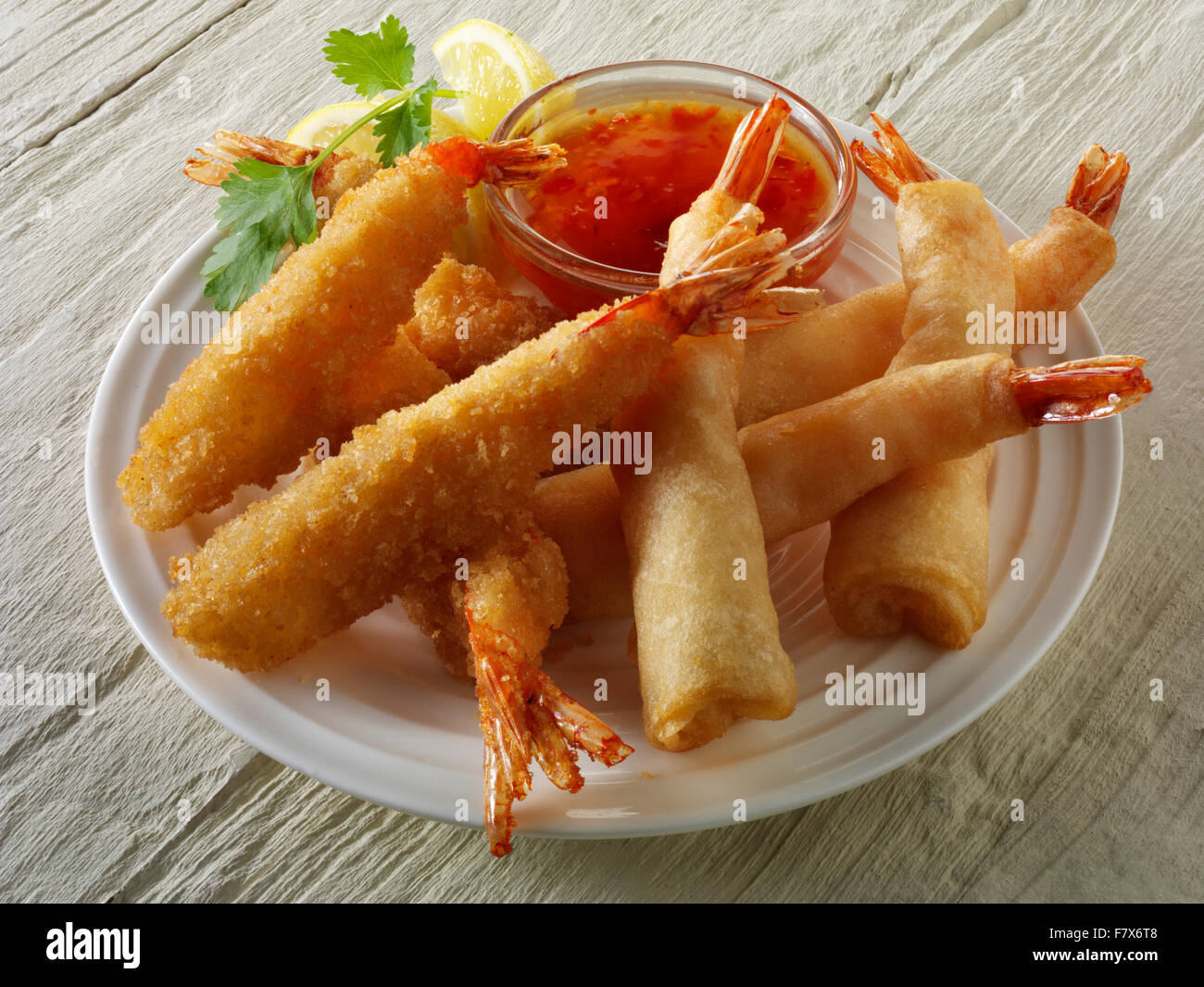 Close up of Oriental Chinese breaded and battered deep fried tiger prawns with a sweet chilli dip ready to eat Stock Photo