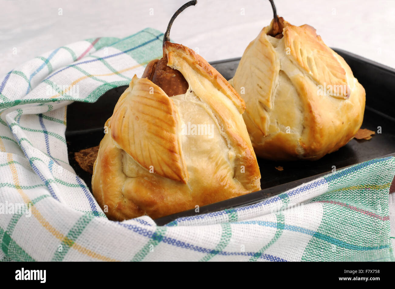 Baked pears stuffed with a mixture of nuts and raisins in the dough Stock Photo