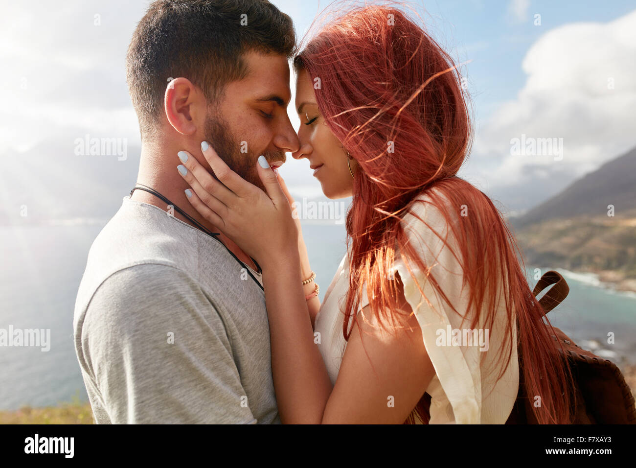 Portrait of affectionate young couple about to kiss. Romantic young man and woman sharing a lovely moment on their summer vacati Stock Photo
