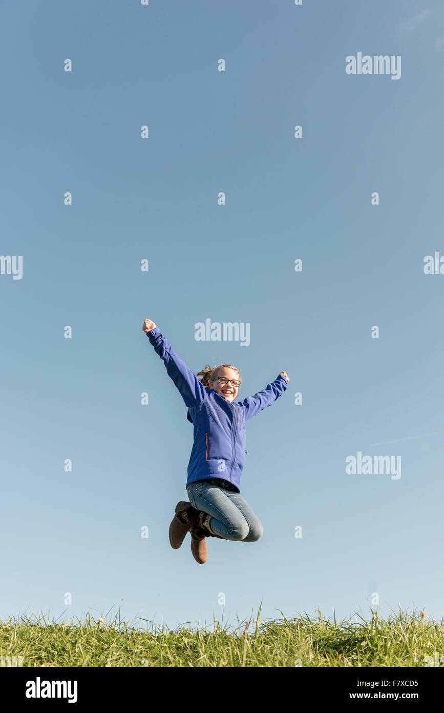 Jumping girl in front of blue sky Stock Photo - Alamy