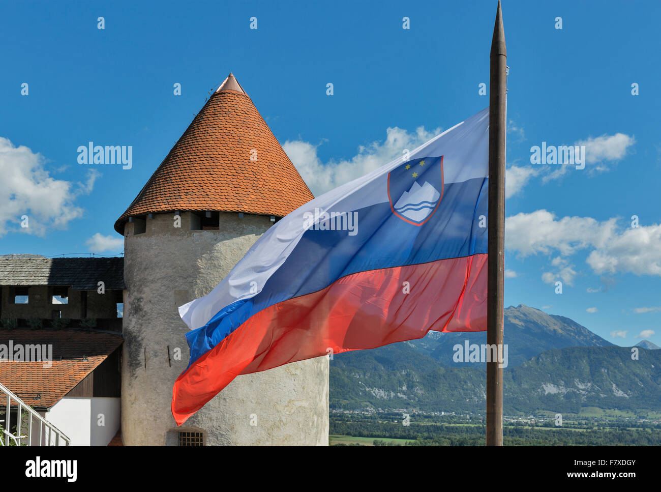 Slovenian national flag fluttering over Bled Castle Stock Photo