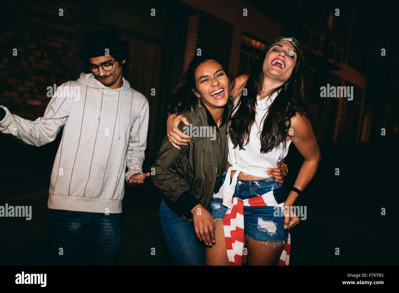 Shot of cheerful young people hanging out at night. Best friends having a party outdoors. Stock Photo