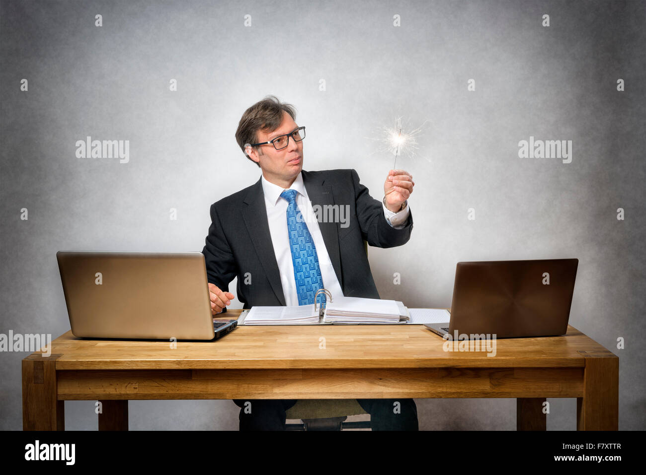 Image of business man with sparkler in office Stock Photo