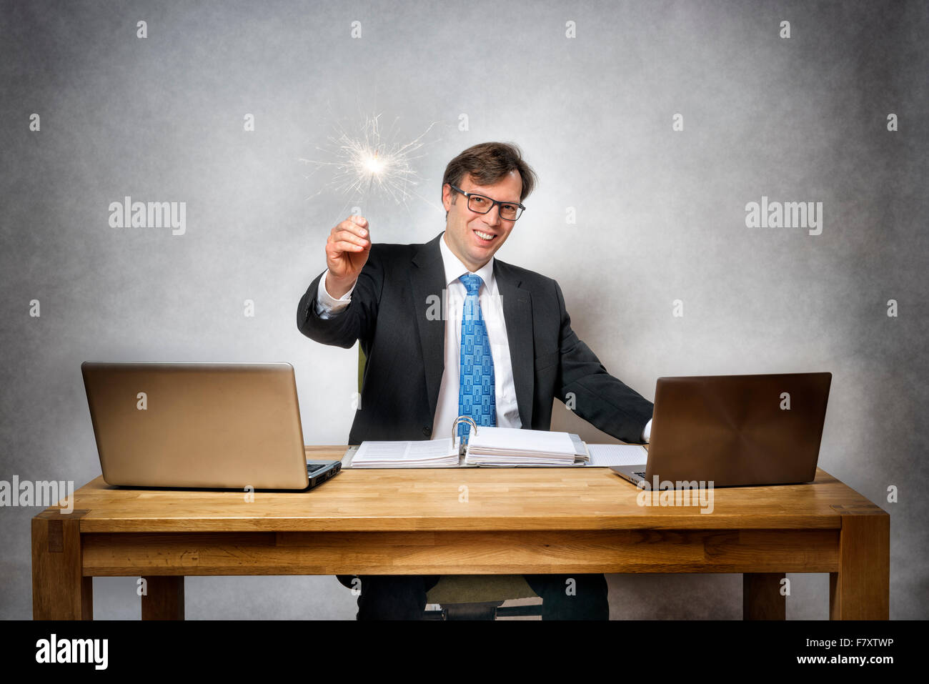Image of business man with sparkler in office Stock Photo