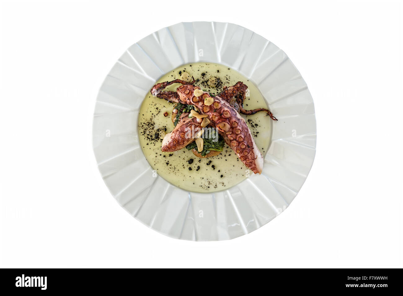 grilled octopus with salted greens and potatoes on white background Stock Photo