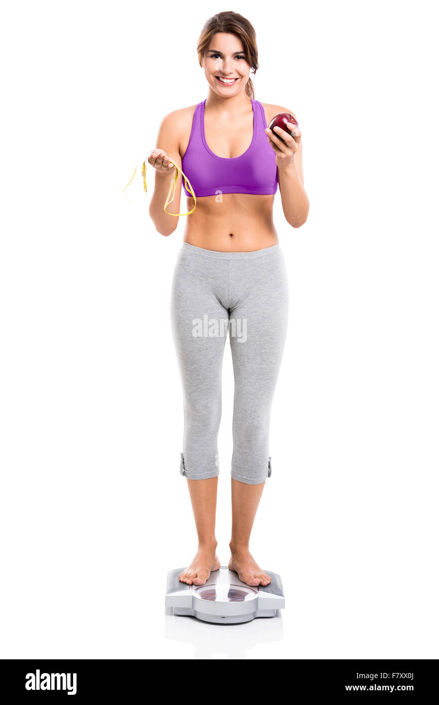 40-year-old housewife with exercise and health care. Girl in exercise  clothes And waist tape measure Sports bra and exercise pants. The girl in  the body fit and firm. Stock Photo
