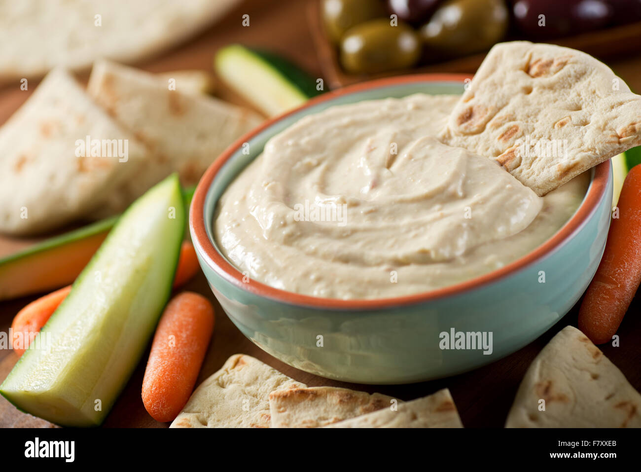A bowl of delicious homemade baba ganoush dip with pita, carrots, cucumber, zucchini, and olives. Stock Photo