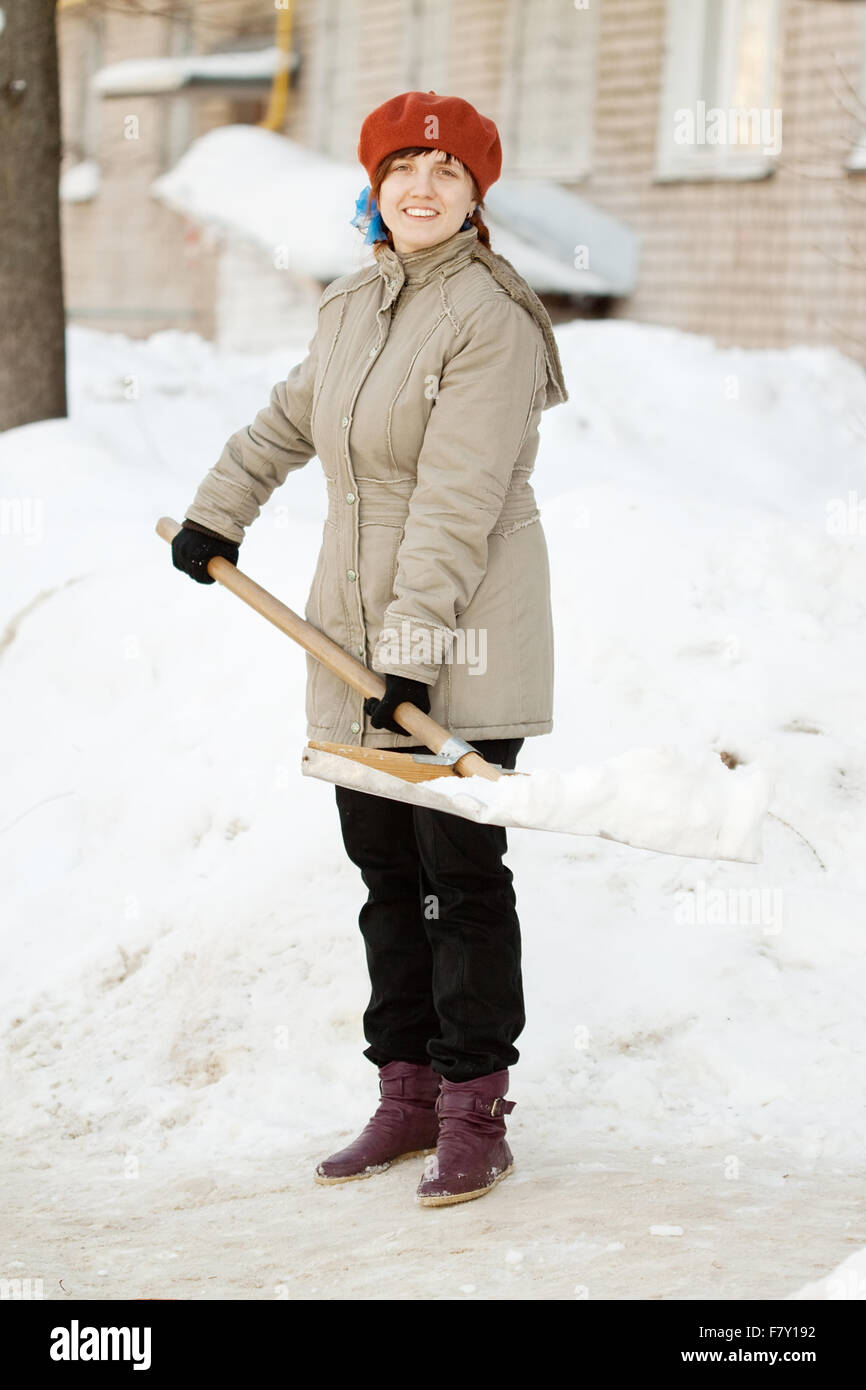 женщина убирает снег. девушка с лопатой. лопата для уборки снега. человек с лопатой зимой. лопата для снега.