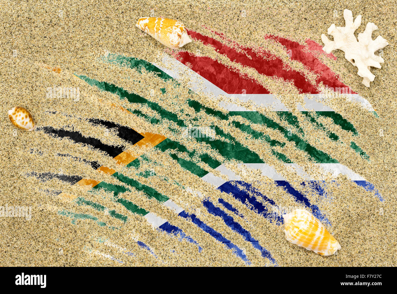 National country flag of South Africa under a beach background with sand, sea shells and coral Stock Photo