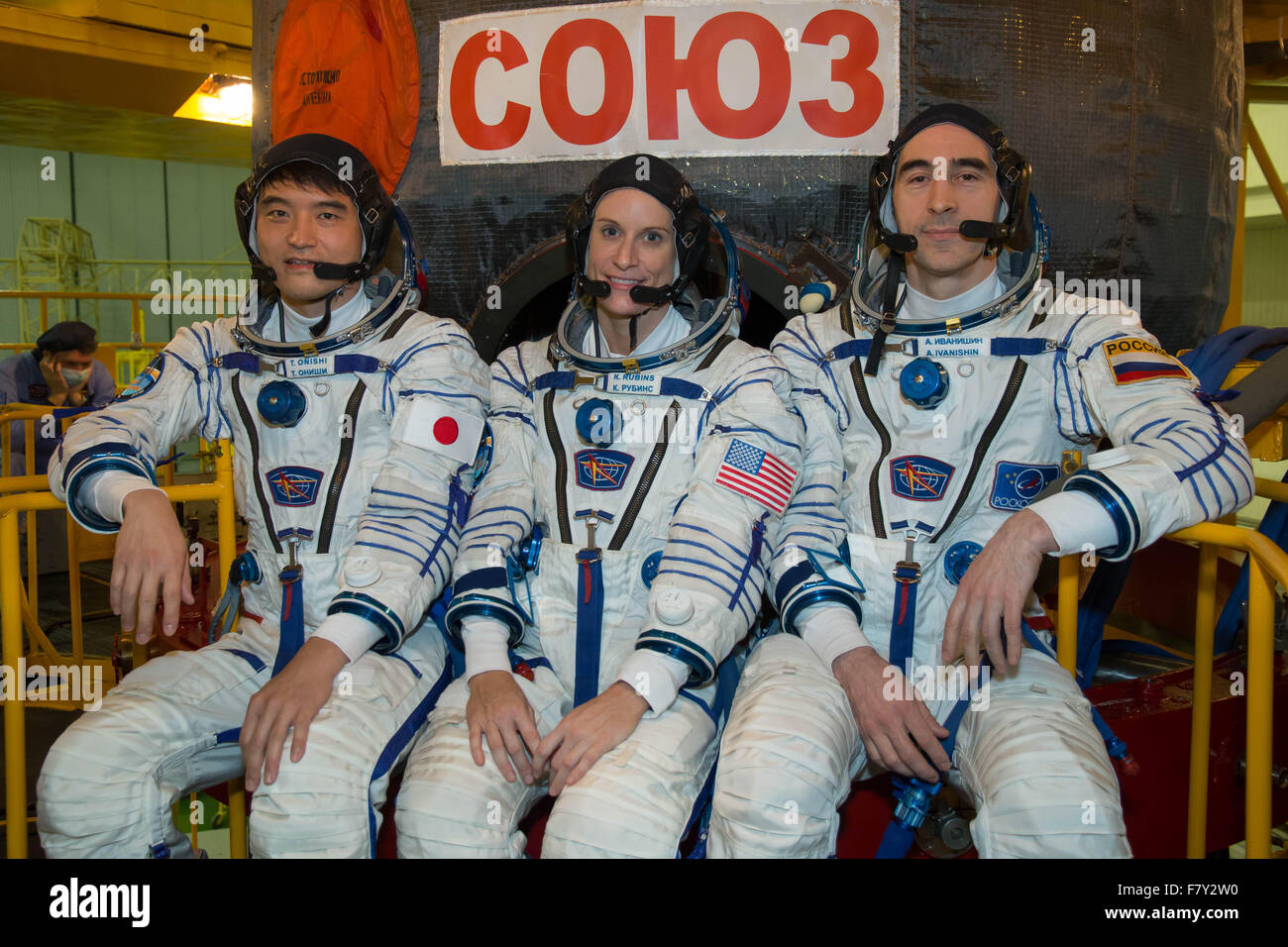 International Space Station Expedition 46 backup crew members pose in front of their Soyuz TMA-19M spacecraft during a crew fit check at the Gagarin Space Center December 1, 2015 in Star City, Russia. Backup crew members (L-R): Japan Aerospace Exploration Agency astronaut Takuya Onishi, NASA astronaut Kate Rubins  and Roscosmos cosmonaut Anatoly Ivanishin. Stock Photo