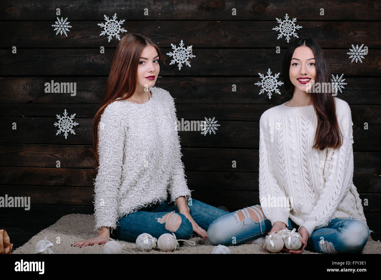 Two beautiful girls sitting on the floor Stock Photo - Alamy