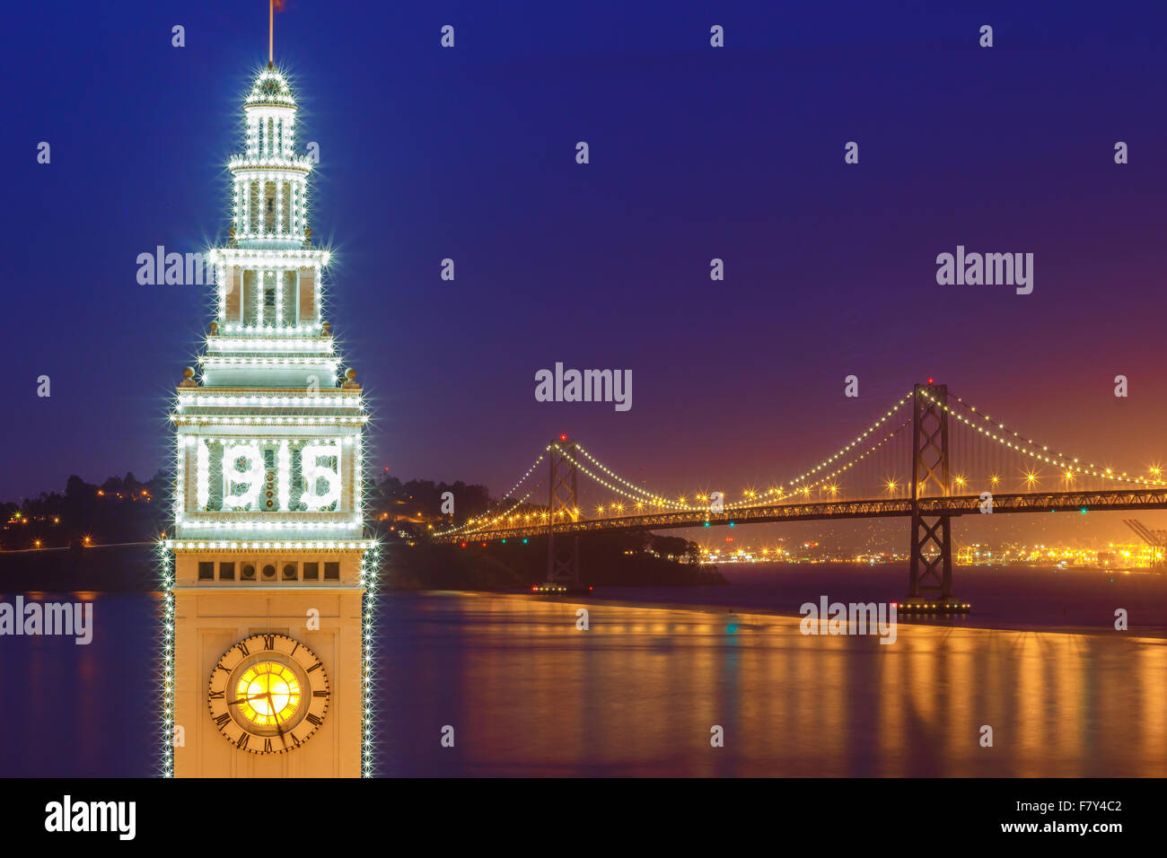 Ferry Building and Bay Bridge illuminated at night in San Francisco, California, USA Stock Photo