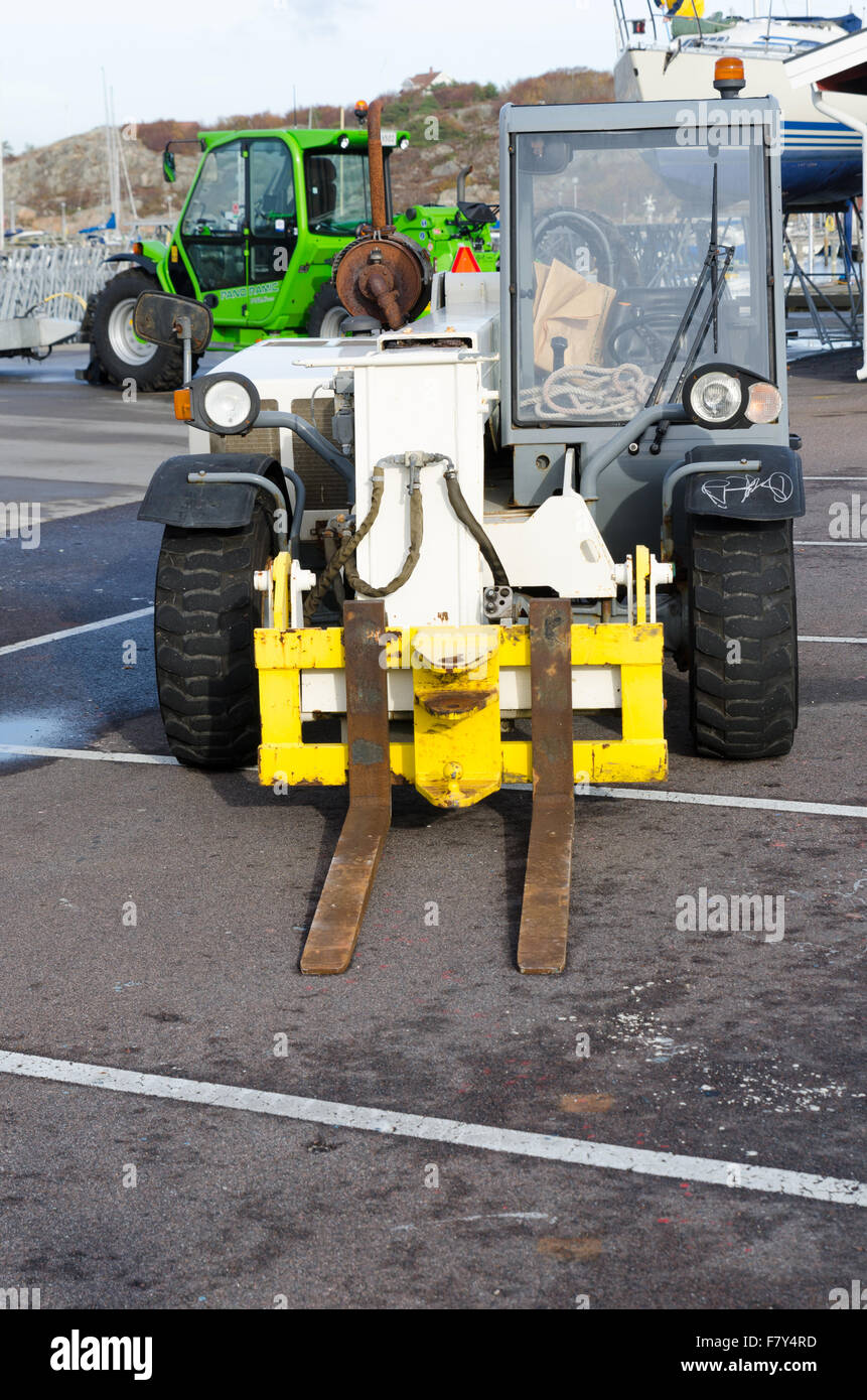 two forklift standing in the harbour and wait to transport boat Stock Photo