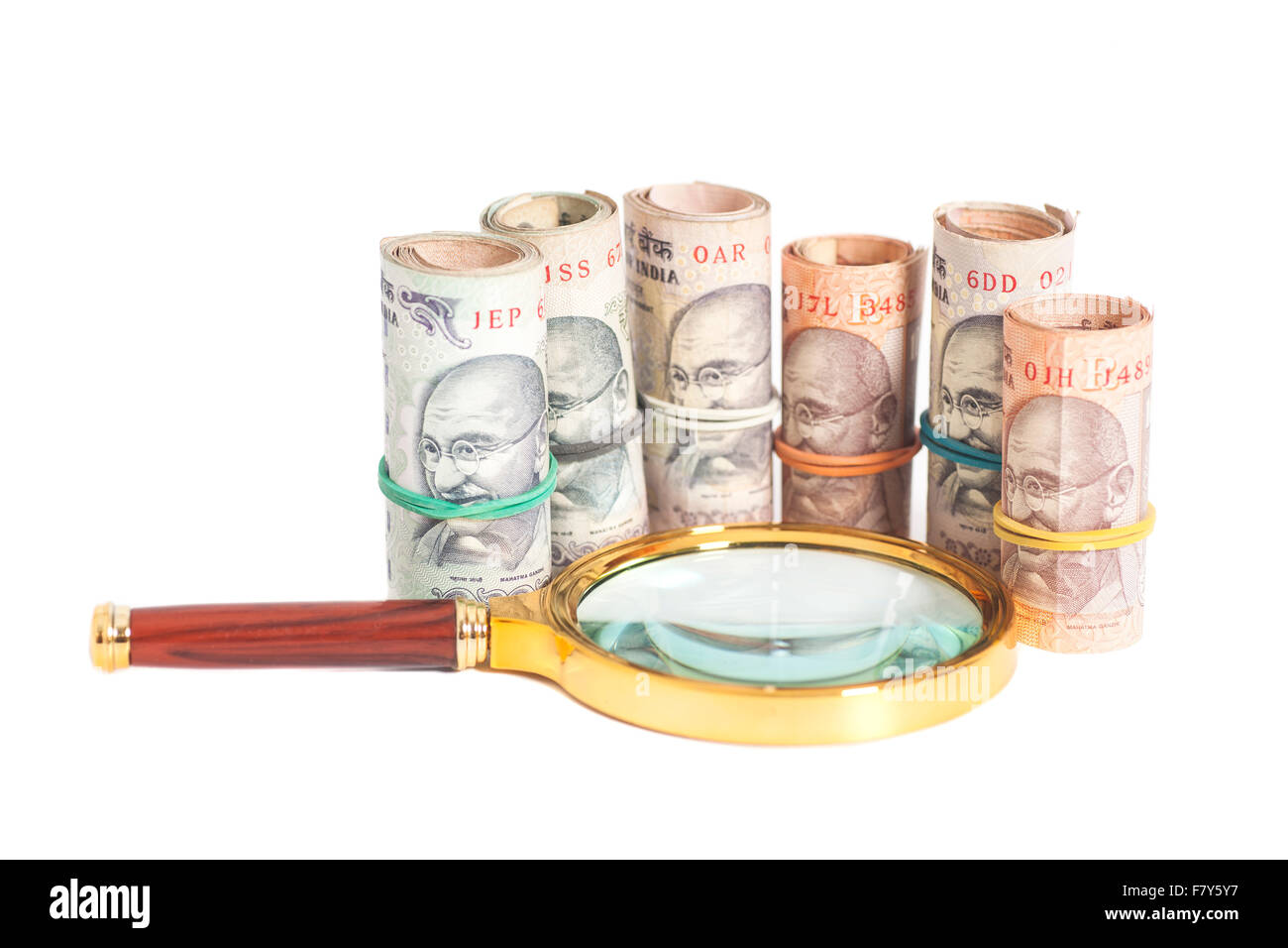 Rolls of Indian Currency Rupee Notes with magnifying glass isolated on ...