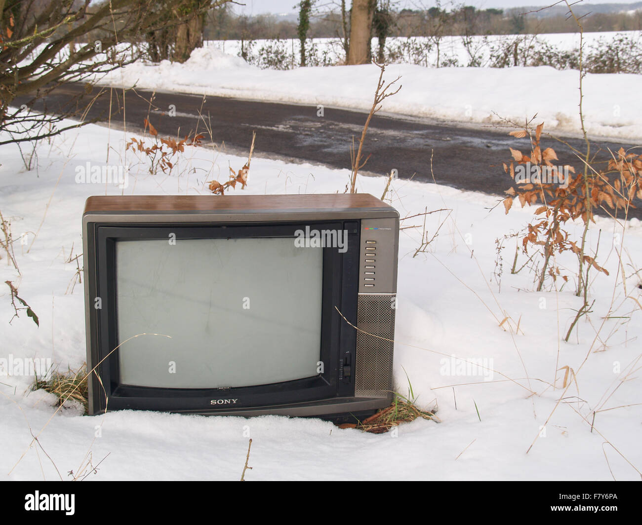A television set left abandoned at the side of a country road in deep white snow in Wiltshire, UK Stock Photo