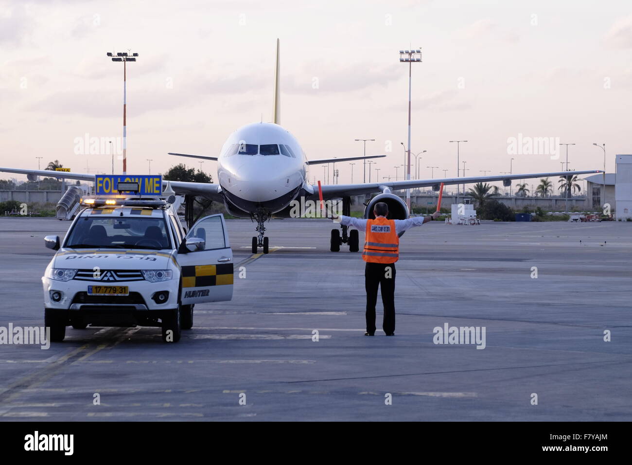 An Airbus A320-200 airplane of Monarch Airlines is directed into position by ground staff after landing in Ben Gurion airport Israel Stock Photo