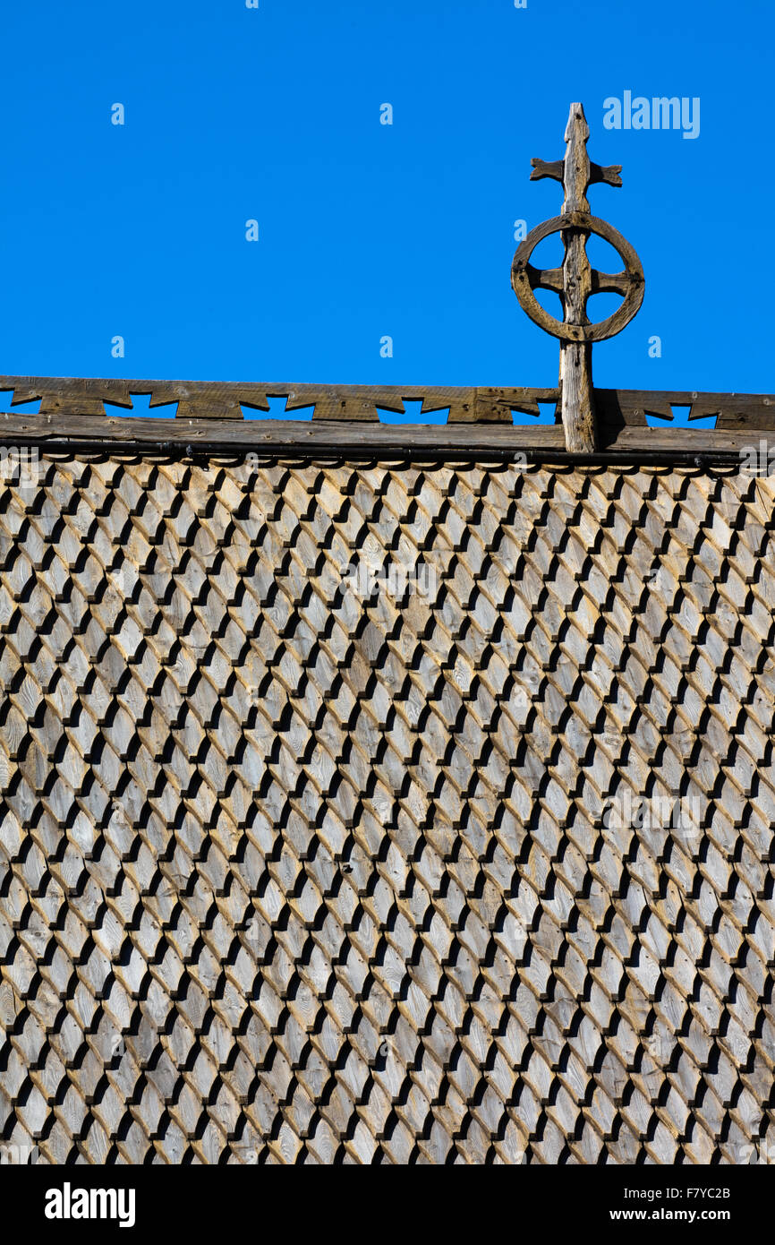 Dragon scale roof of wooden shingles with cross on the ancient Lom