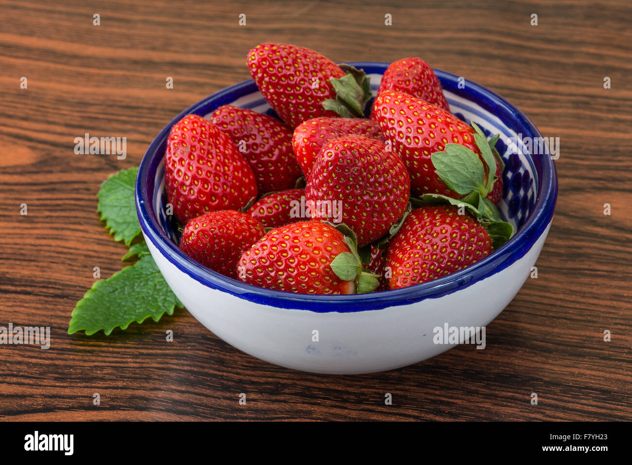 Fresh ripe strawberries in the bowl on wooden background Stock Photo ...