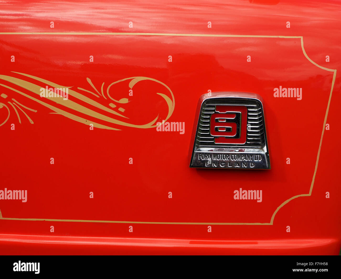 bright red panel of vintage commercial vehicle with gold painted decoration and silver Ford Motor Co chrome name badge Stock Photo