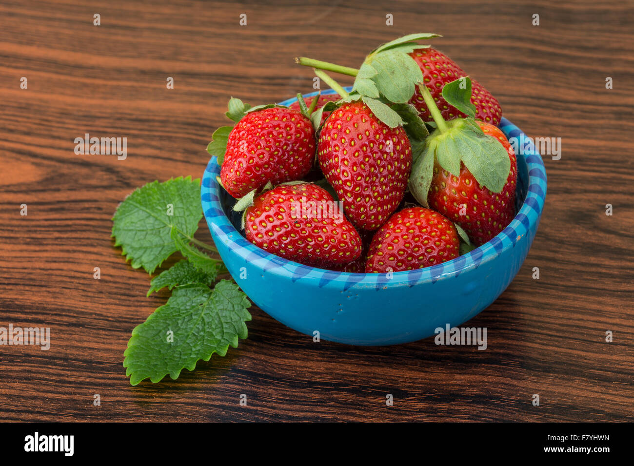Fresh ripe strawberries in the bowl on wooden background Stock Photo ...