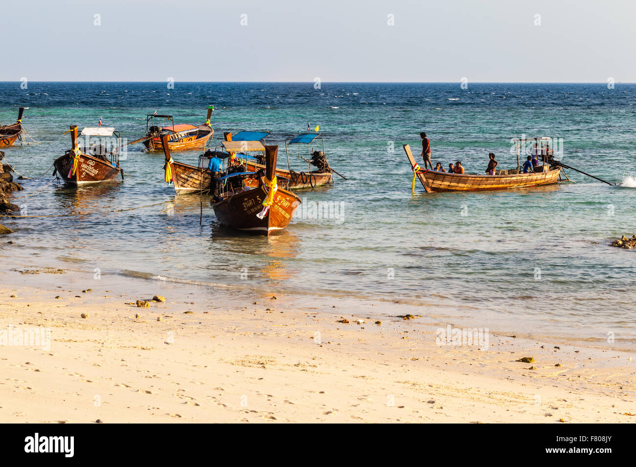 several long tail boats floating in a calm tropical sea Stock Photo