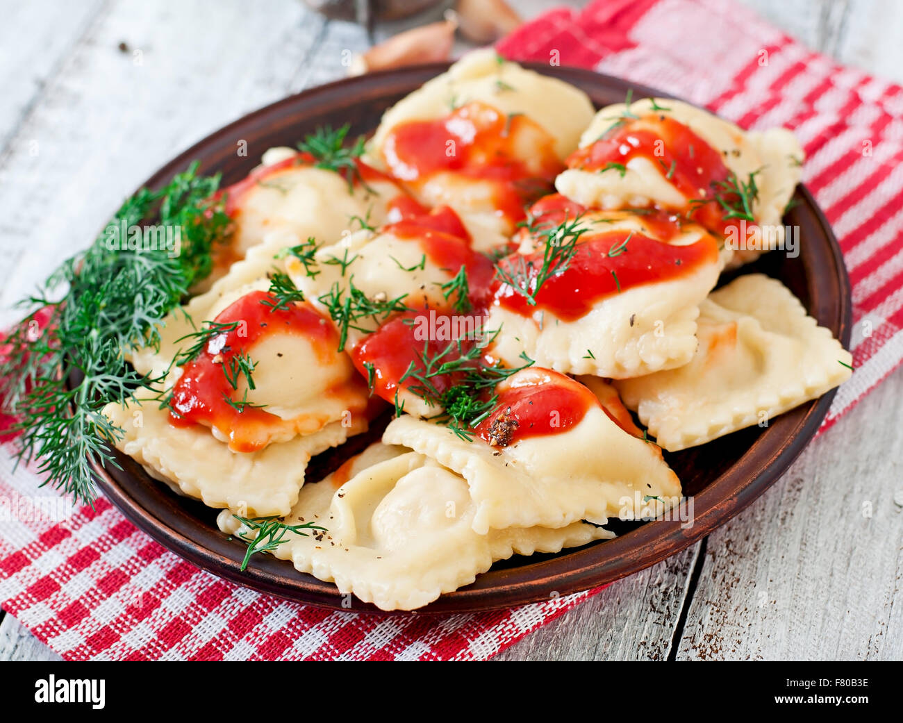 Delicious ravioli with tomato sauce and dill Stock Photo - Alamy