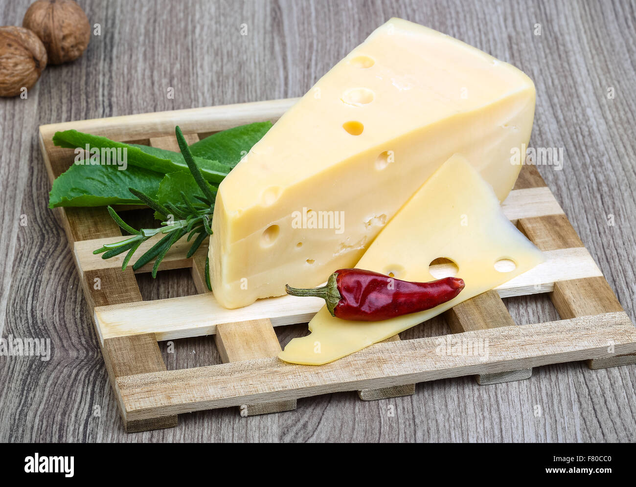 Triangle Pepper Triangle yellow cheese with rosemary, pepper and salad leaves Stock ...